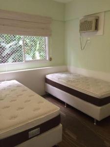 - 2 lits dans une chambre avec fenêtre dans l'établissement Apto no Condominio Porto Real Resort, à Mangaratiba