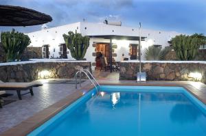 a swimming pool in front of a house at El Caserío de Güime Villa con Piscina Climatizada in San Bartolomé