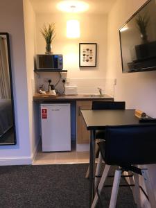 a small kitchen with a table and a sink at Glaisdale Studios in Wolverhampton