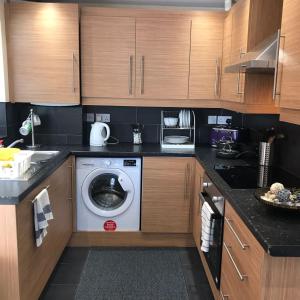 a kitchen with a washing machine in a kitchen at Glaisdale Studios in Wolverhampton +4 photos