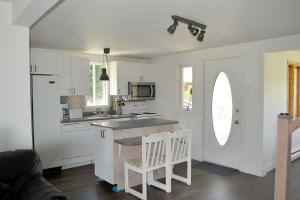a kitchen with white cabinets and a counter top at Les 4 chalets - Le 609 in Lac-Saint-Paul