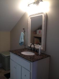 y baño con lavabo y espejo. en Charming home in Derby city en Louisville