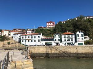 a group of buildings on a hill next to a river at Pensión Basagoiti in Getxo