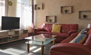 Sala de estar con 2 sofás rojos y TV en Residence du Galtz, en Colmar