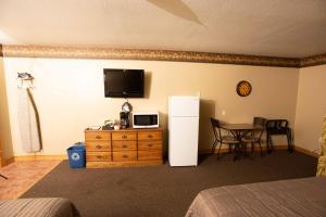 a room with a refrigerator and a table with a tableablish at Blue Spruce Motel in Massena