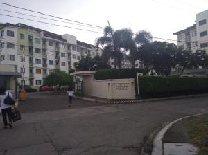 a woman walking down a street next to a building at Spacious Studio unit beside Enchanted Kingdom at Santa Rosa City Laguna in Santa Rosa