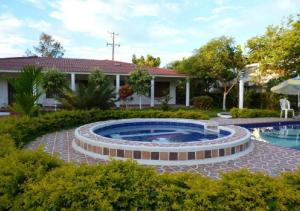 un cortile con piscina e una casa di Finca Campestre con Piscina en Villavicencio a Granja El Hachón