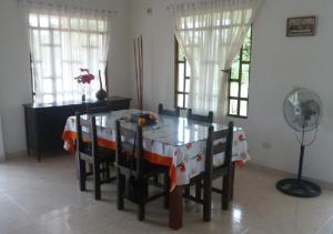 uma sala de jantar com uma mesa com cadeiras e uma ventoinha em Finca Campestre con Piscina en Villavicencio em Granja El Hachón