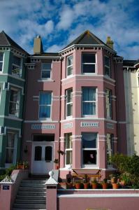 une maison rose avec des escaliers devant elle dans l'établissement Athol Park Guest House, à Port Erin