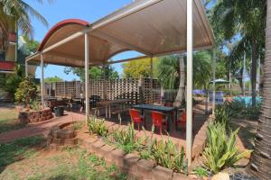 a pavilion with tables and red chairs under it at Katherine River Lodge in Katherine