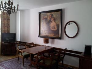 een eetkamer met een tafel en een schilderij aan de muur bij Dom Architekta in Kazimierz Dolny