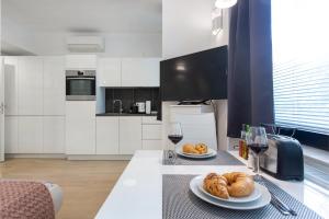 a kitchen with two plates of bread and wine glasses at Urban Style Apartments by Loft in Ljubljana