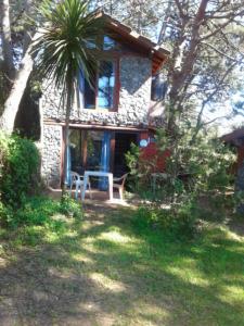 una casa con una palmera y una mesa delante de ella en Cabañas Mar Azul en Balneario Mar Azul