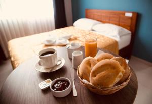einen Frühstückstisch mit einem Korb mit Brot und Orangensaft in der Unterkunft Hotel Jorge Chavez in Trujillo