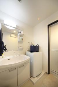 baño con lavabo, espejo y nevera en EX Itoman Apartment 203, en Itoman
