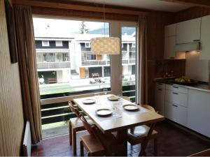 a kitchen with a table with chairs and a large window at Las Bargias 9 (457 Bo) in Lenzerheide