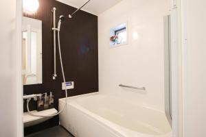 a bathroom with a white tub and a sink at Uhome Ikebukuro Villa 2 in Tokyo +58 photos