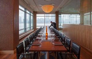 a man sitting at a long table in a room with windows at Hyatt Regency Jersey City in Jersey City