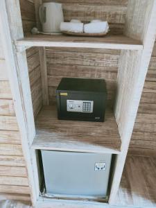 a microwave on a shelf with a box on it at Tiki bar and more in Nusa Lembongan