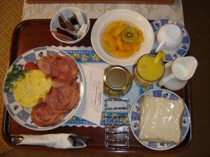 a tray of breakfast food with eggs and fruit at Mana-Nui Motel in Whitianga