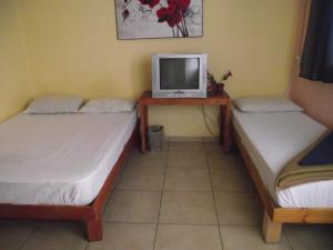 2 Betten in einem Zimmer mit einem TV auf einem Tisch in der Unterkunft Hotel 28 in Tel Aviv