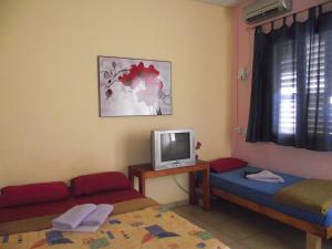 um pequeno quarto com duas camas e uma televisão em Hotel 28 em Tel Aviv