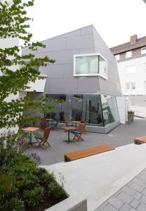 a glass house on a roof with chairs and tables at Hotel Barth in Kaiserslautern