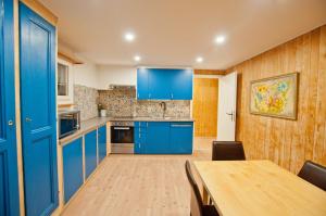 a kitchen with blue cabinets and a wooden table at 2BR apartment close to ski area and Jungfrau train in Grindelwald