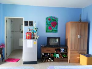 a blue room with a refrigerator and a tv at One-D Homestay in Sattahip