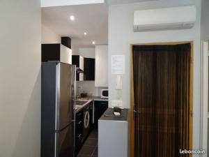 una cucina con elettrodomestici in bianco e nero e frigorifero di Coeur Vieil Antibes Plages à Pied a Antibes