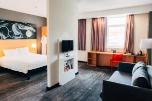 a hotel room with a bed and a tv at Ibis Cheboksary Center in Cheboksary