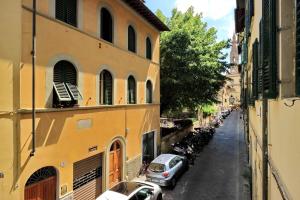 un vicolo con auto parcheggiate in una strada tra due edifici di 31 Borgo Allegri a Firenze