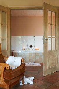 a bathroom with a shower and a chair and a tub at Hotel VILLINO in Lindau