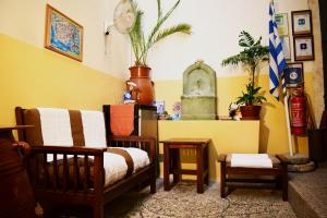 un salon rempli de meubles et un mur jaune dans l'établissement Stoa Rooms, à La Canée