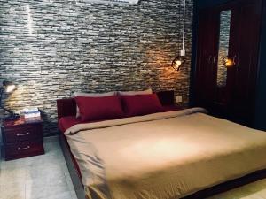 sypialnia z łóżkiem i ceglaną ścianą w obiekcie 08 Homestay w mieście Cần Thơ