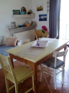 uma mesa de jantar com um vaso com uma flor em Loft "Le Rosier" em Villar Perosa