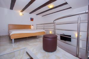 a bedroom with a bed and a bench in a room at Apartments Lara in Podgora