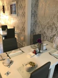 a white table with two chairs and a table with flowers on it at Sorrento House in Blackpool