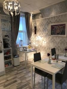 a living room with a table and chairs and a kitchen at Sorrento House in Blackpool
