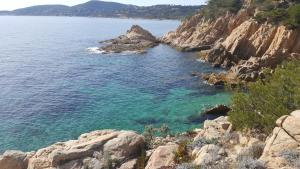 a large body of water with rocks and the ocean at 65 Rue Pierre Rameil Appartement in Cavalaire-sur-Mer +7 photos