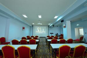 a conference room with tables and chairs and a screen at Konfor Hotel Burabay in Borovoye