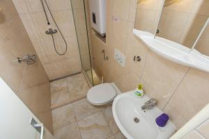a bathroom with a shower and a sink and a toilet at Apartments Lara in Podgora +48 photos