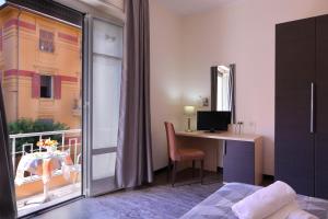 a room with a bed and a desk and a window at Hotel Ferrari in Chiavari