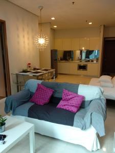 a living room with a couch with purple pillows at Soho Suites KLCC Elite 2 in Kuala Lumpur