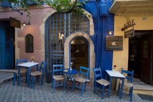 eine Gruppe von Tischen und Stühlen vor einem Gebäude in der Unterkunft Nostos Hotel in Chania