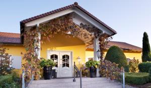 una casa amarilla con una puerta blanca en Hotel VILLINO en Lindau