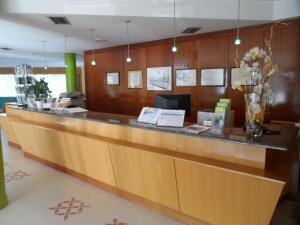 eine Lobby mit einer Empfangstheke mit einer Blumenvase in der Unterkunft Hotel Rey Arturo Burgos in Villagonzalo-Pedernales