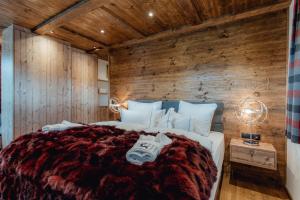a bedroom with a bed with a wooden wall at Chalet Olivia in Seefeld in Tirol +74 photos