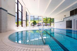 een zwembad in een gebouw met een zwembad bij Hotel Tangram in Shinano