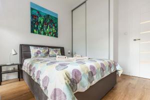 1 dormitorio con 1 cama y una pintura en la pared en Perfect Apartament en Lublin